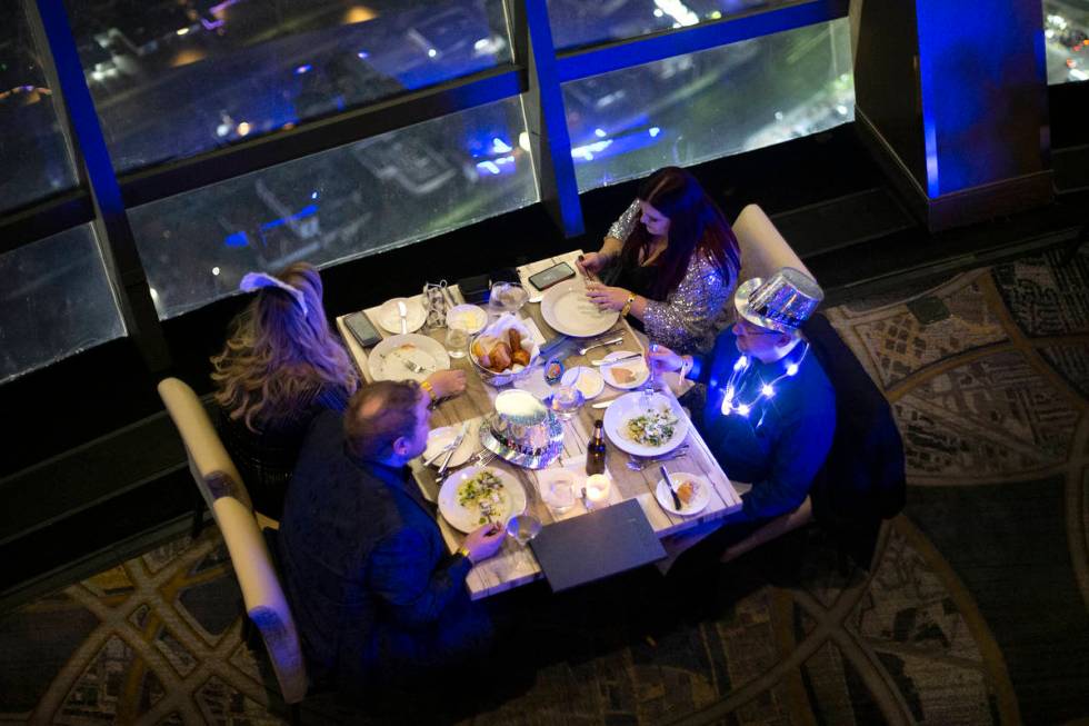Diners enjoy at New Year's Eve dinner at the Top of the World restaurant at The STRAT on Thursd ...