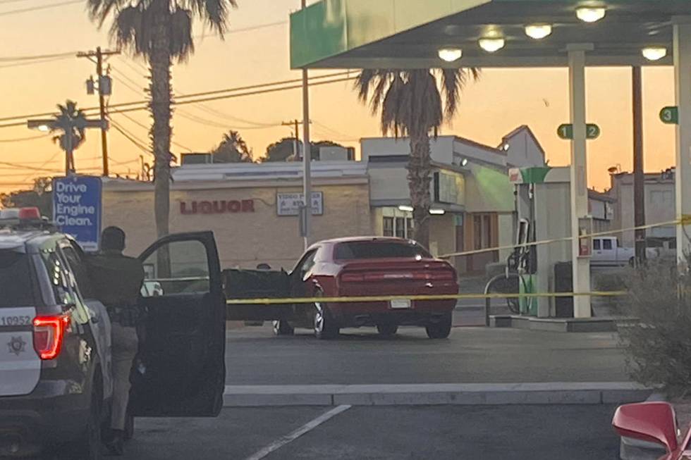 Las Vegas police surround a red Dodge car in front of a Sinclair gas station shortly after 6:30 ...