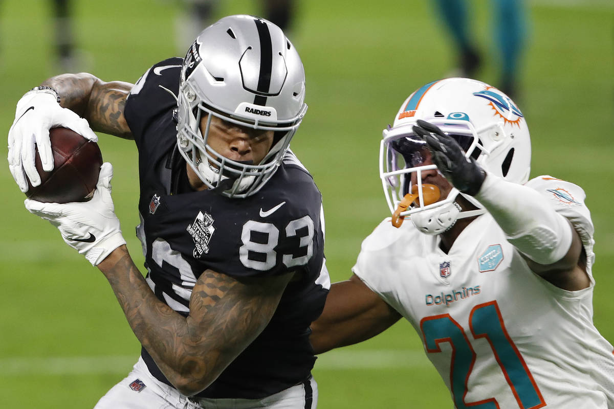 Las Vegas Raiders tight end Darren Waller (83) makes a catch over Miami Dolphins free safety Er ...