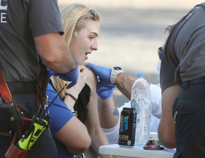 A health-care worker reacts as she receives the COVID-19 vaccine at Lake-Sumter State College i ...