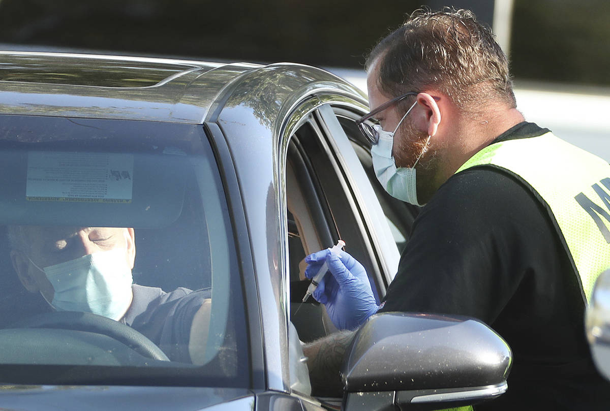 Health care professionals administer the COVID-19 vaccine at Lake-Sumter State College in Leesb ...