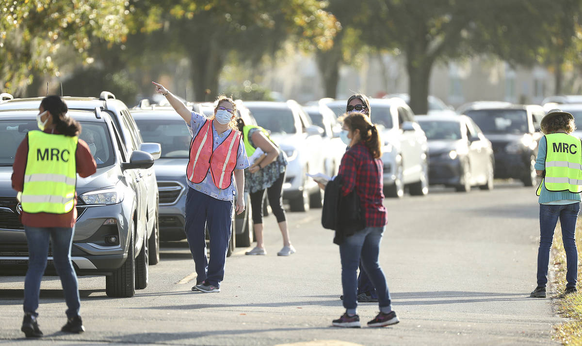 Traffic is directed toward the COVID-19 vaccine site at Lake-Sumter State College in Leesburg, ...