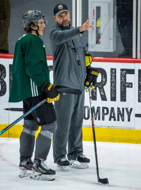 Vegas Golden Knights head coach Peter DeBoer, right, talks with left wing Peyton Krebs (18) on ...