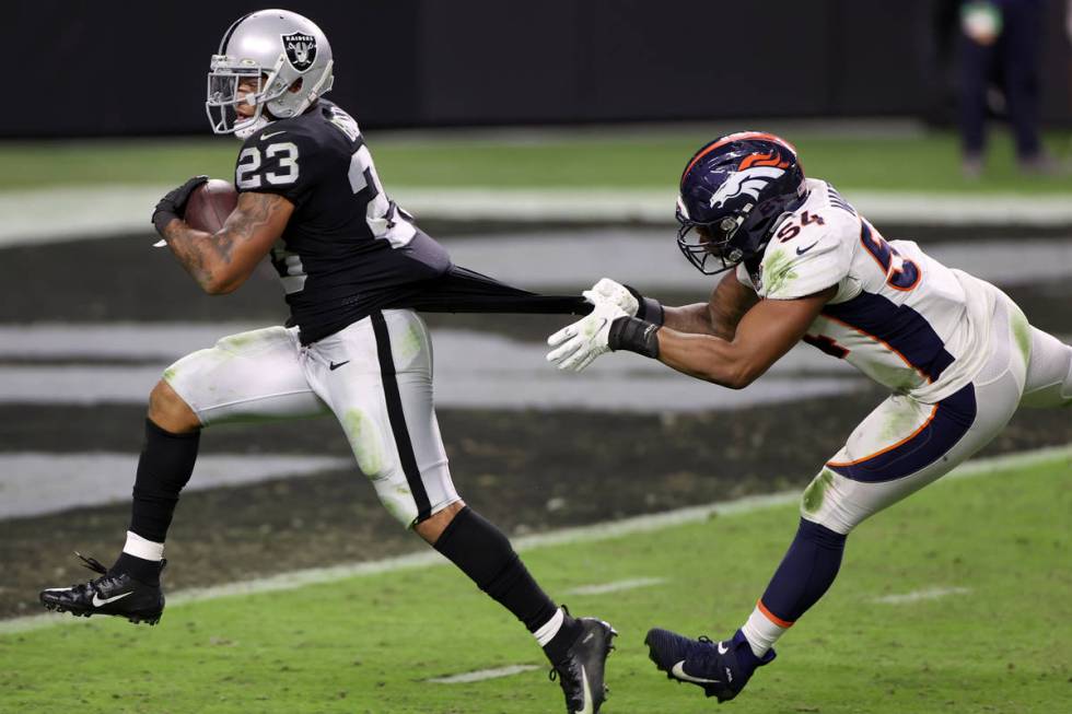 Las Vegas Raiders running back Devontae Booker (23) runs for a touchdown as Denver Broncos line ...