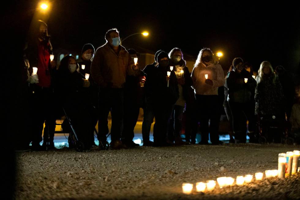 Attendees take a moment of silence for Eric Echevarria, a 52-year-old father and husband who wa ...