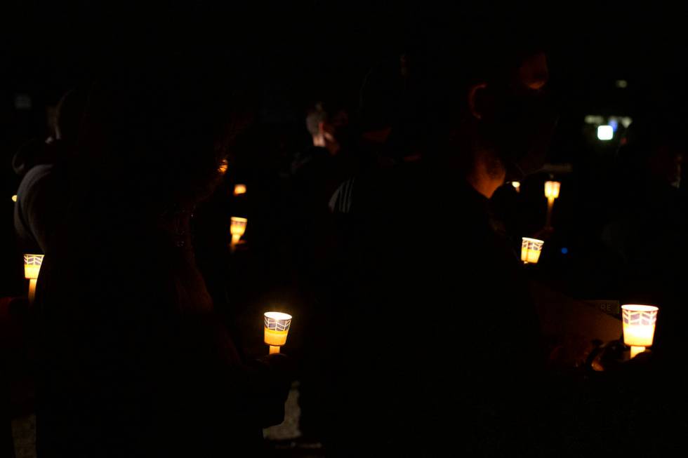 A crowd holds candles in honor of Eric Echevarria, a 52-year-old father and husband who was kil ...