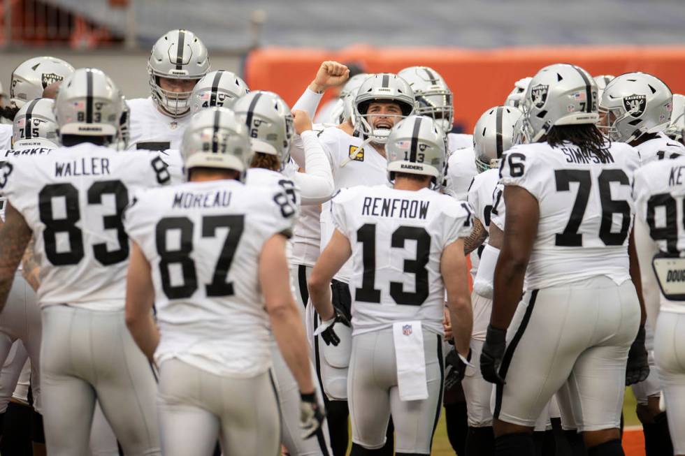 Raiders quarterback Derek Carr, middle, fires up his team during warm ups before the start of a ...