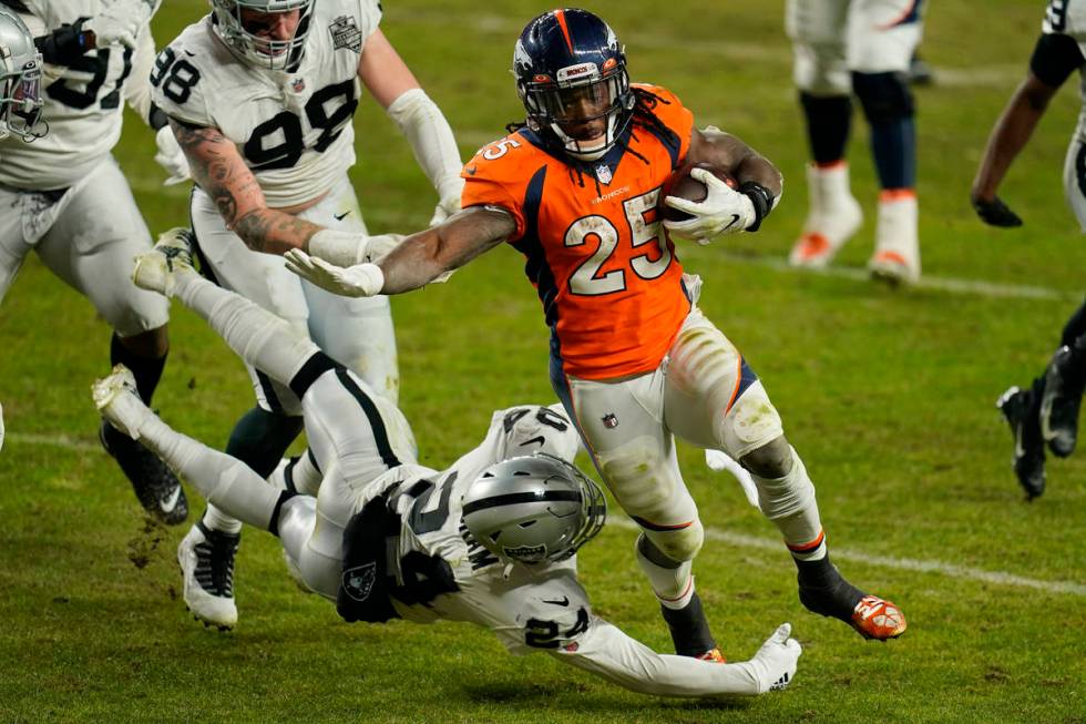 Denver Broncos running back Melvin Gordon (25) avoids a tackle by Las Vegas Raiders strong safe ...