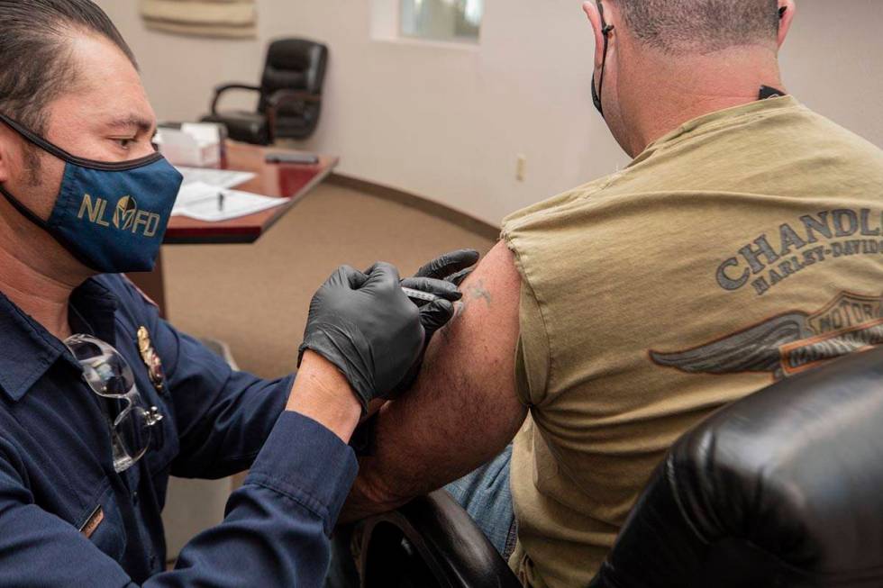 The North Las Vegas Fire Department's fire equipment specialist Victor Mancilla, left, administ ...