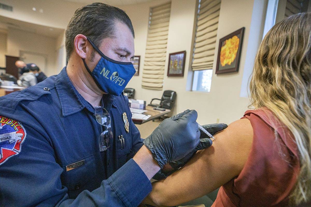 The North Las Vegas Fire Department's fire equipment specialist Victor Mancilla, left, administ ...