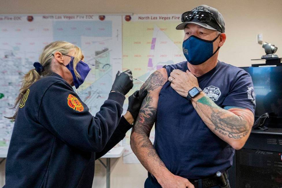 Emergency medical services chief Lisa Price, left, administers a COVID-19 vaccine to North Las ...