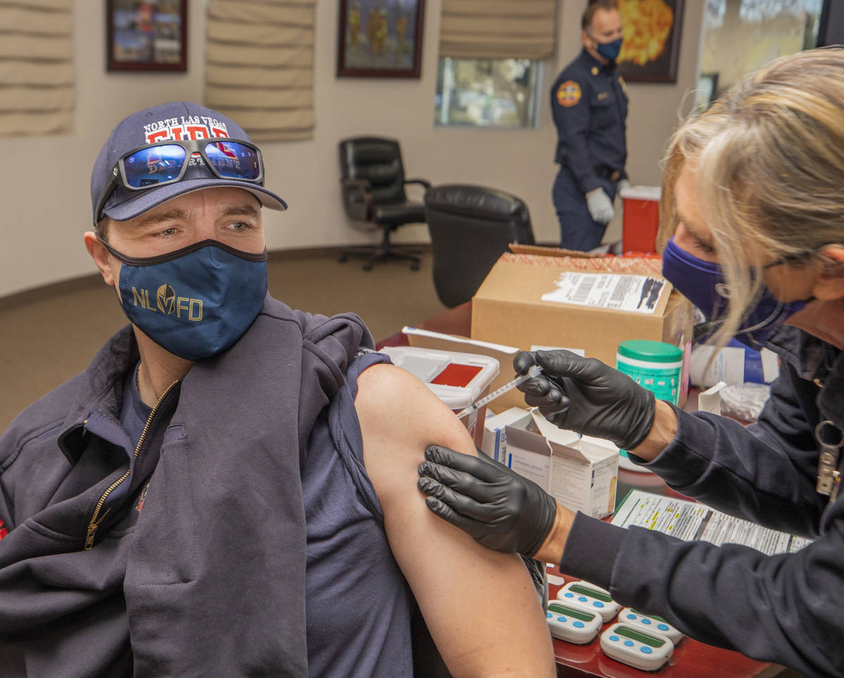 North Las Vegas Fire Department captain David Carraway, 36, left, is administrated a COVID-19 v ...