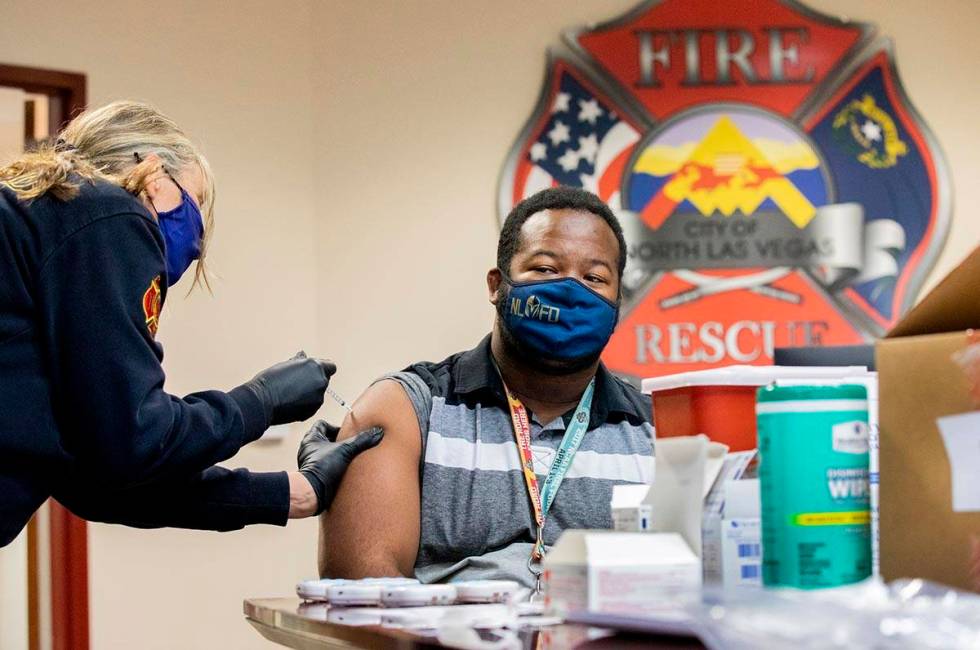 Emergency medical services chief Lisa Price, left, administers a COVID-19 vaccine to North Las ...