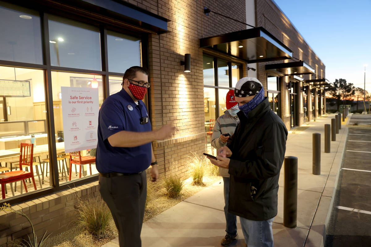 Ryan N., left, grand opening trainer, helps John Forte of Las Vegas use the mobile app for orde ...