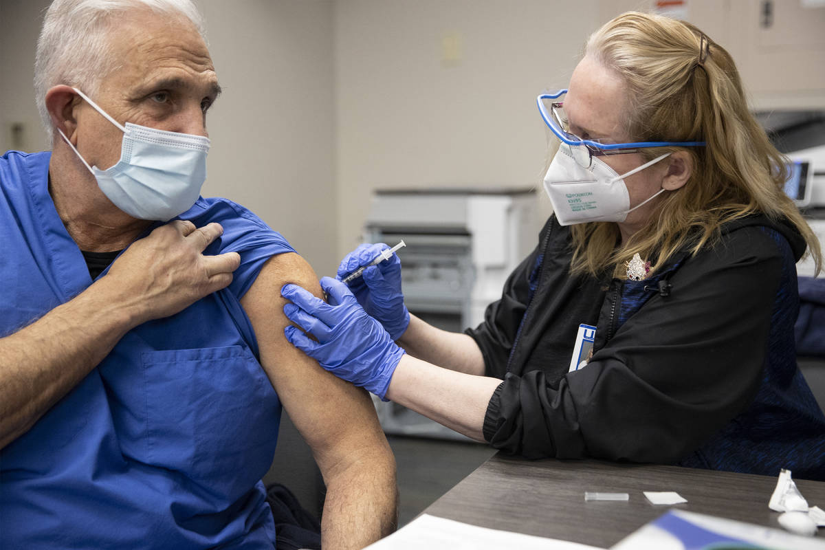 Registered Nurse Cass Petrykowski, left, receives the second dose of the Pfizer COVID-19 vaccin ...