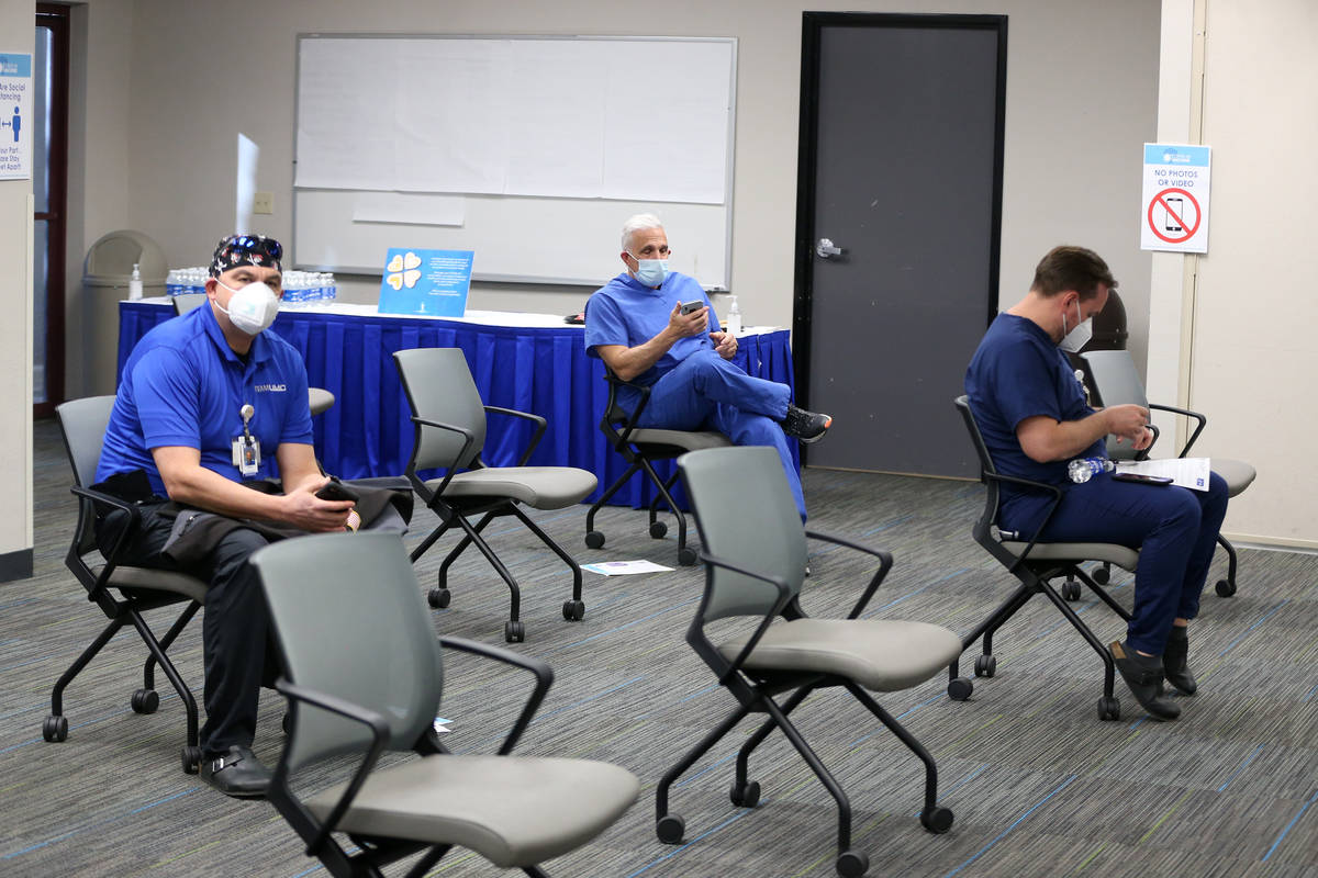 Registered Nurse Cass Petrykowski, center, waits after receiving the second dose of the Pfizer ...