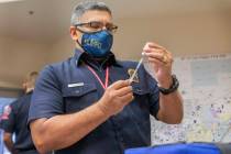 The North Las Vegas Fire Department health care coordinator Fernando Juarez fills a syringe wit ...