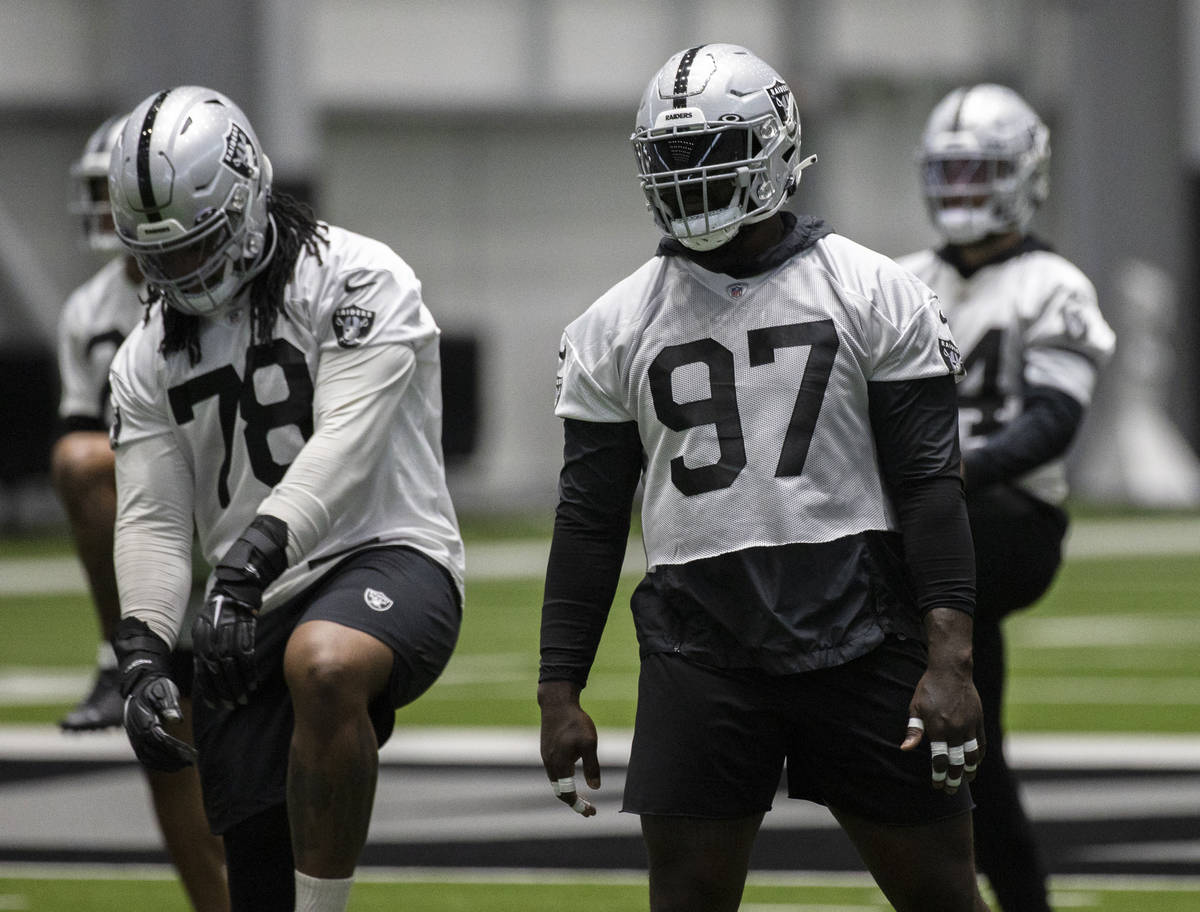 Raiders defensive tackle Maliek Collins (97) stretches during NFL football training camp practi ...