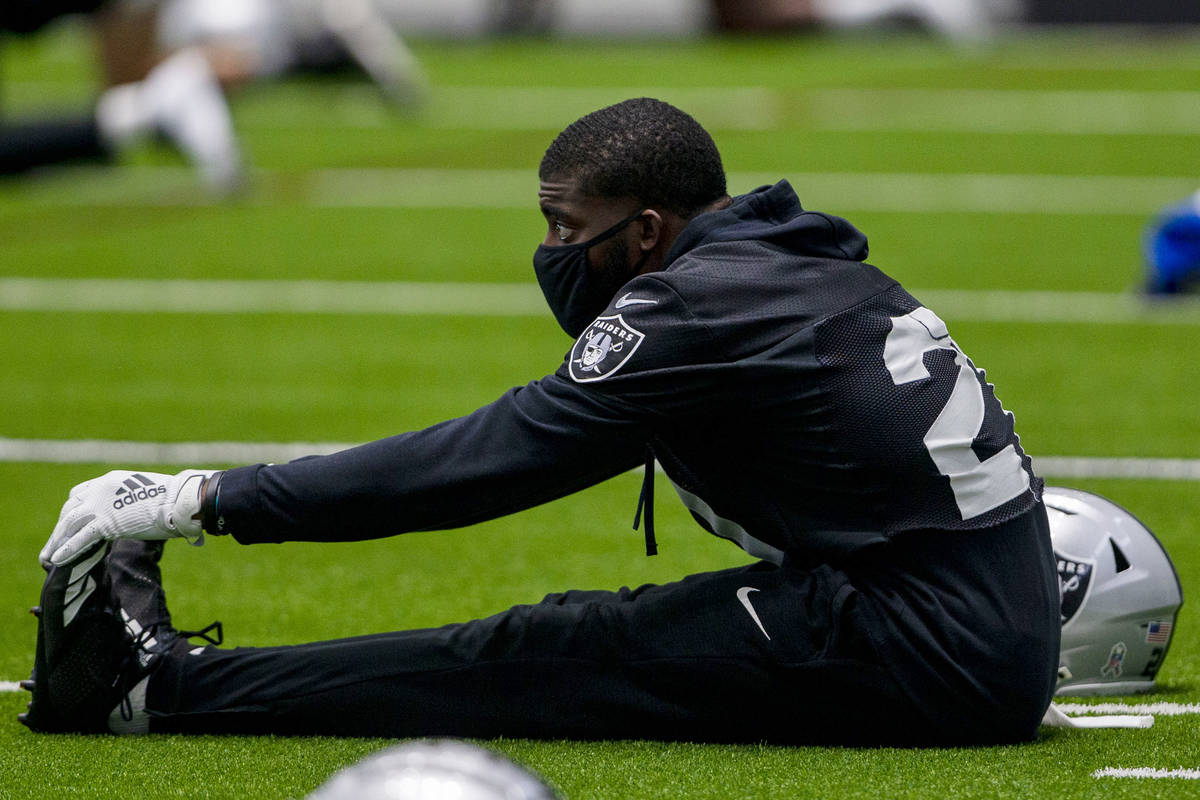 Las Vegas Raiders cornerback Amik Robertson (21) wears a mask while stretching during a practic ...