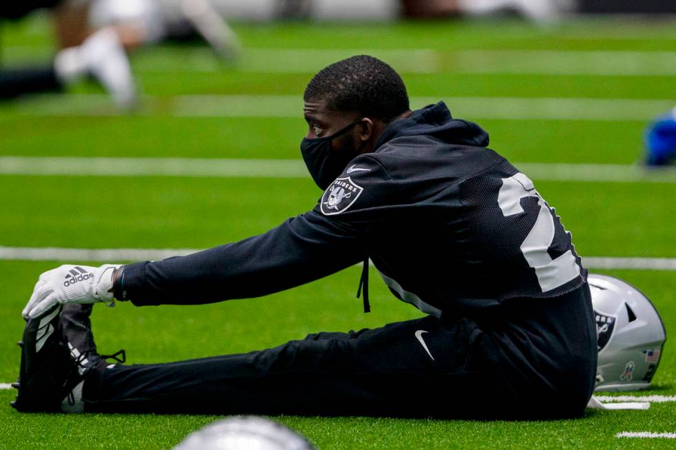 Las Vegas Raiders cornerback Amik Robertson (21) wears a mask while stretching during a practic ...