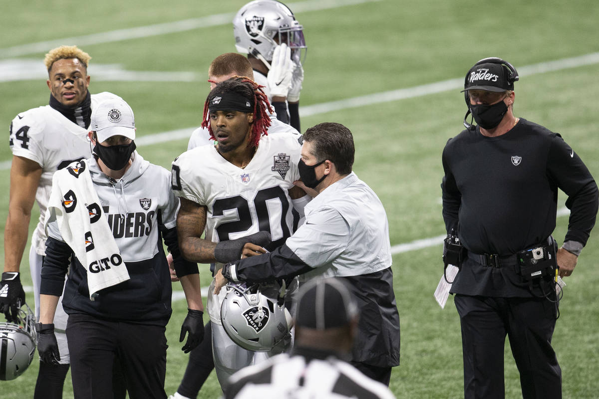 Las Vegas Raiders cornerback Damon Arnette (20) is helped off the field by trainers after being ...