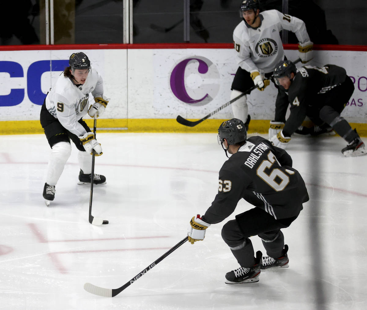 Golden Knights center Cody Glass (9) looks to move the puck past defenseman Carl Dahlstrom (63) ...