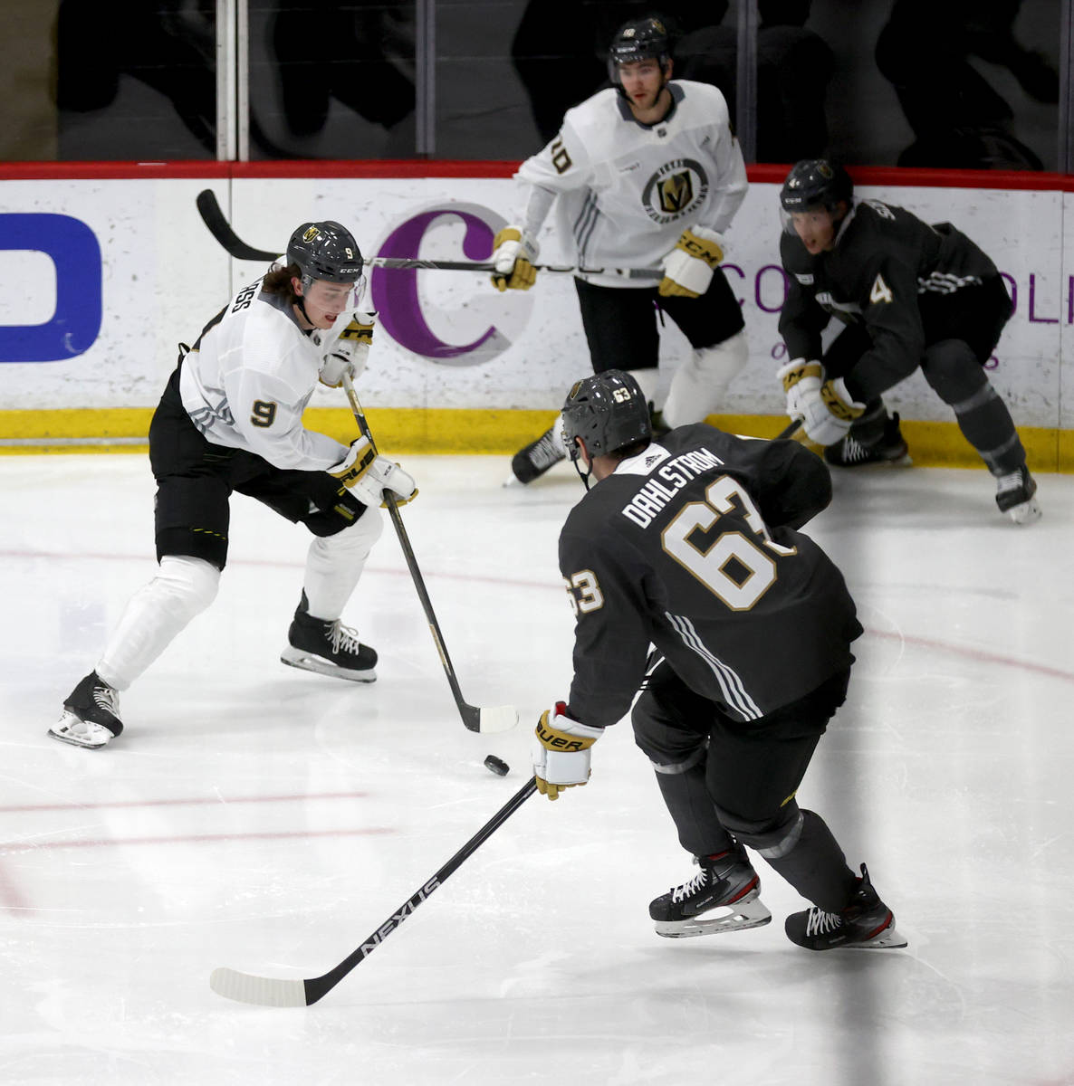 Golden Knights center Cody Glass (9) looks to move the puck past defenseman Carl Dahlstrom (63) ...