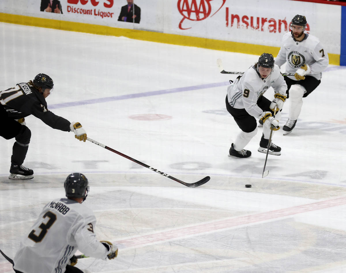 Golden Knights center Cody Glass (9) moves the puck past center William Karlsson (71) as defens ...