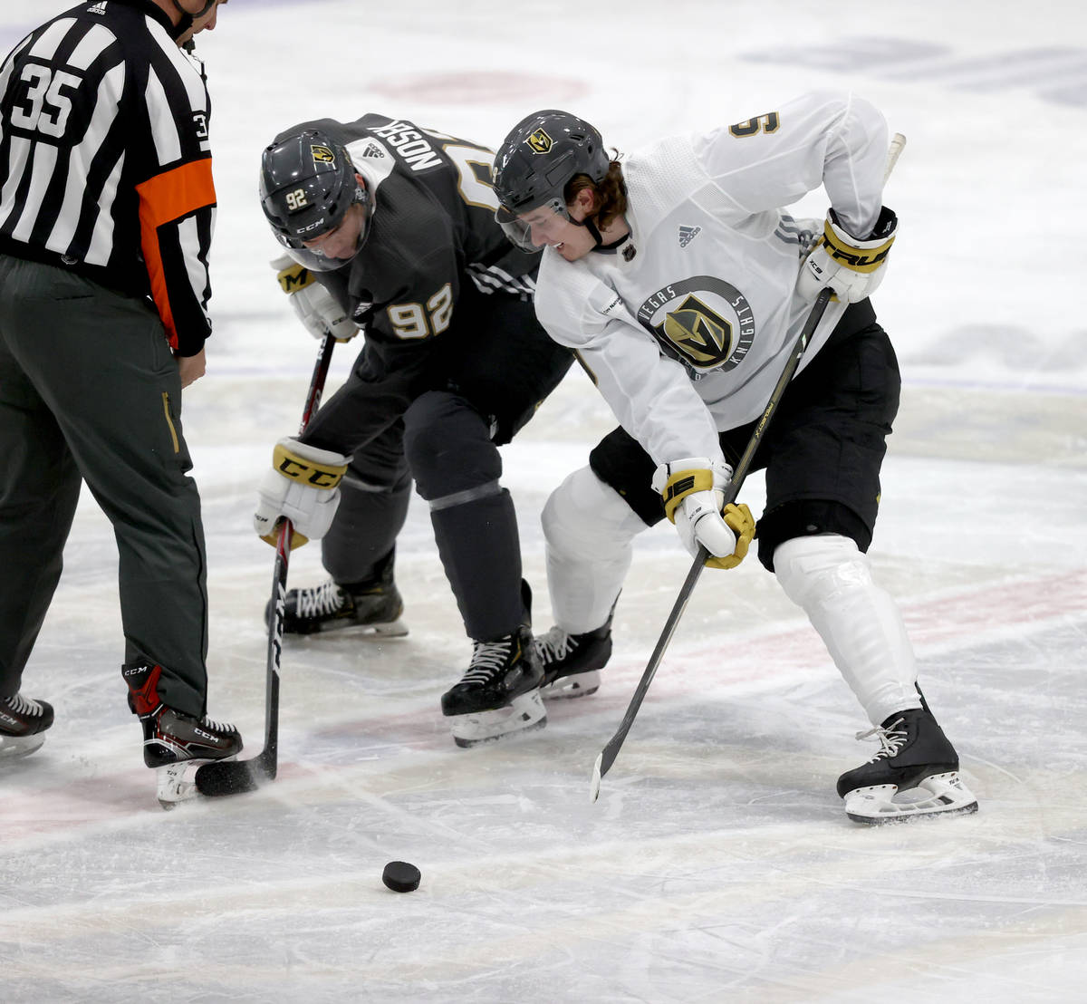Golden Knights center Cody Glass (9) faces off against Golden Knights center Tomas Nosek (92) d ...