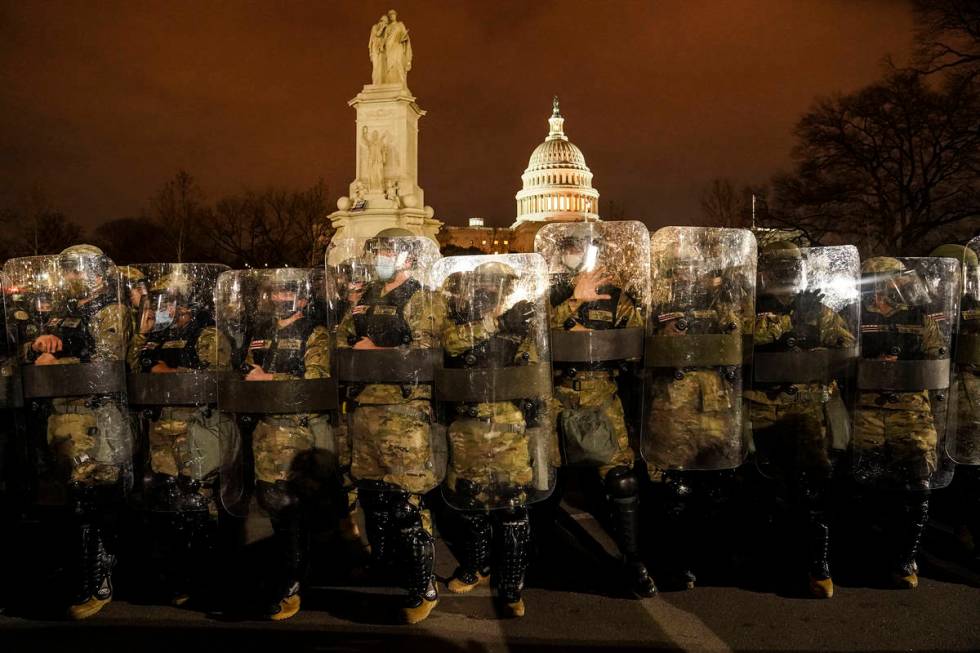 District of Columbia National Guard stand outside the Capitol, Wednesday night, Jan. 6, 2021, a ...