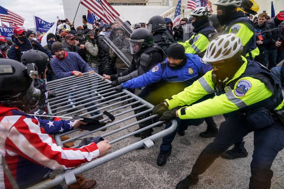 Trump supporters try to break through a police barrier, Wednesday, Jan. 6, 2021, at the Capitol ...
