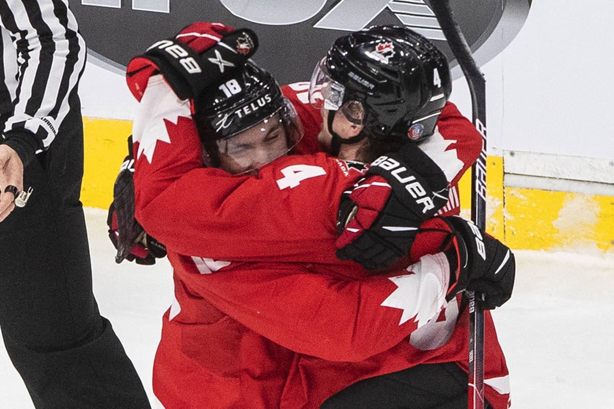 Canada's Peyton Krebs (18) and Bowen Byram (4) celebrate a goal against the Czech Republic duri ...