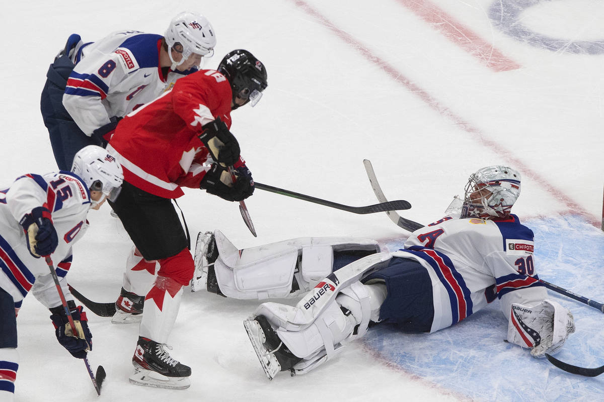 Canada's Peyton Krebs (18) is stopped by United States goalie Spencer Knight (30) during the th ...