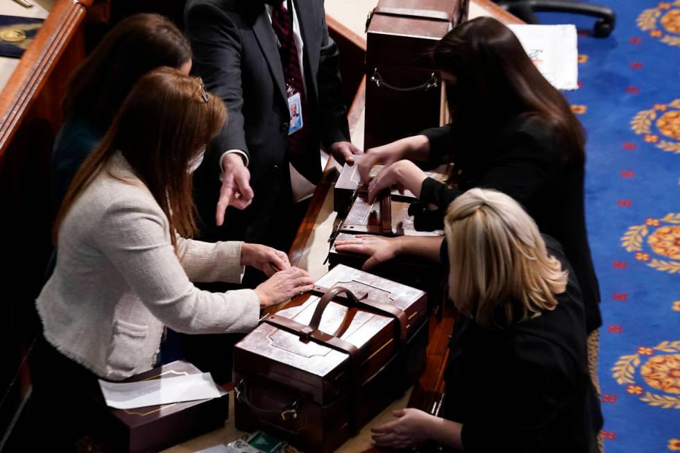 Staff members close boxes containing Electoral College votes after an objection to confirming v ...