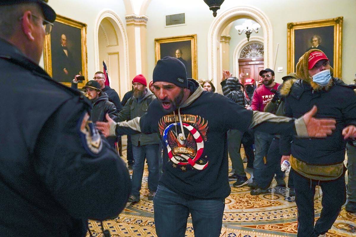 Trump supporters gesture to U.S. Capitol Police in the hallway outside of the Senate chamber at ...