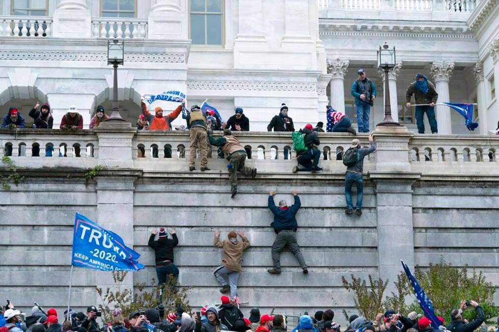 Supporters of President Donald Trump climb the west wall of the the U.S. Capitol on Wednesday, ...