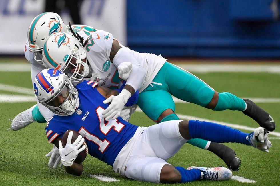 Buffalo Bills wide receiver Stefon Diggs (14) is tackled by Miami Dolphins safety Bobby McCain ...