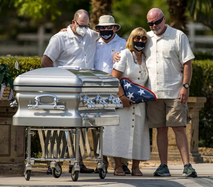 Mourners gather about the casket during a burial service for Metro Lt. Erik Lloyd at the Palm N ...