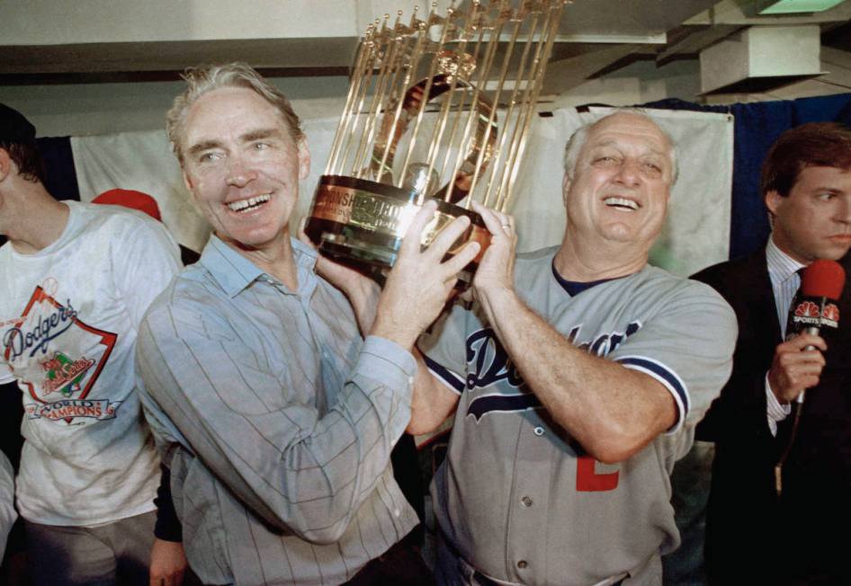 Los Angeles Dodgers manager Tommy Lasorda, right, and Fred Claire, Dodgers' vice president, hoi ...