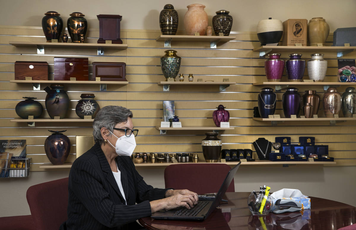 Laura Sussman of Kraft-Sussman Funeral and Cremation Services works at a desk inside a display ...
