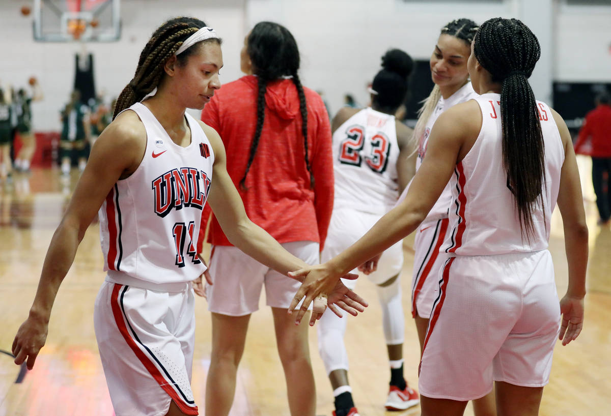 UNLV Lady Rebels guard Bailey Thomas (14), left, high fives sister and guard Jade Thomas (5), w ...