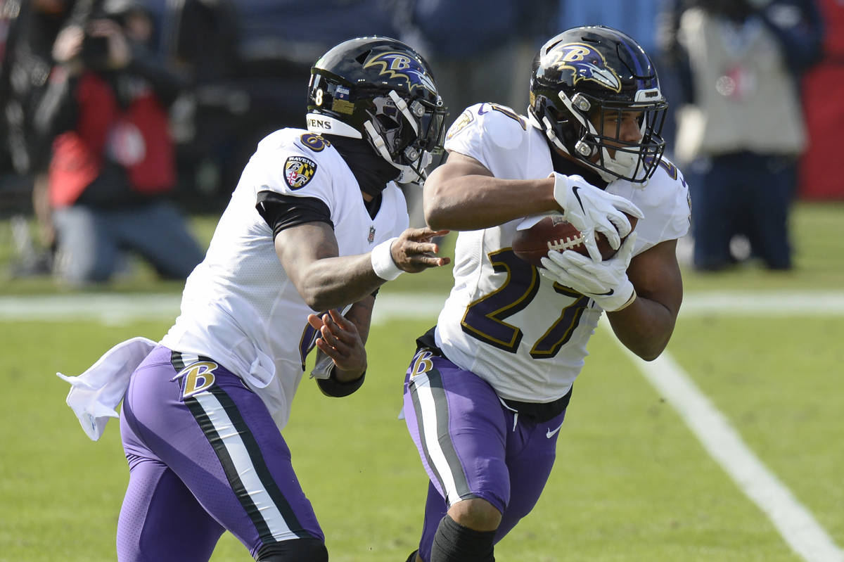 Baltimore Ravens running back J.K. Dobbins (27) takes a handoff from quarterback Lamar Jackson ...