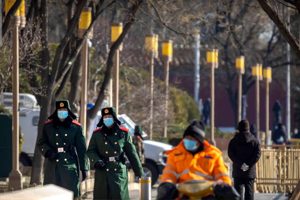 Chinese paramilitary police wearing face masks to protect against the spread of the coronavirus ...