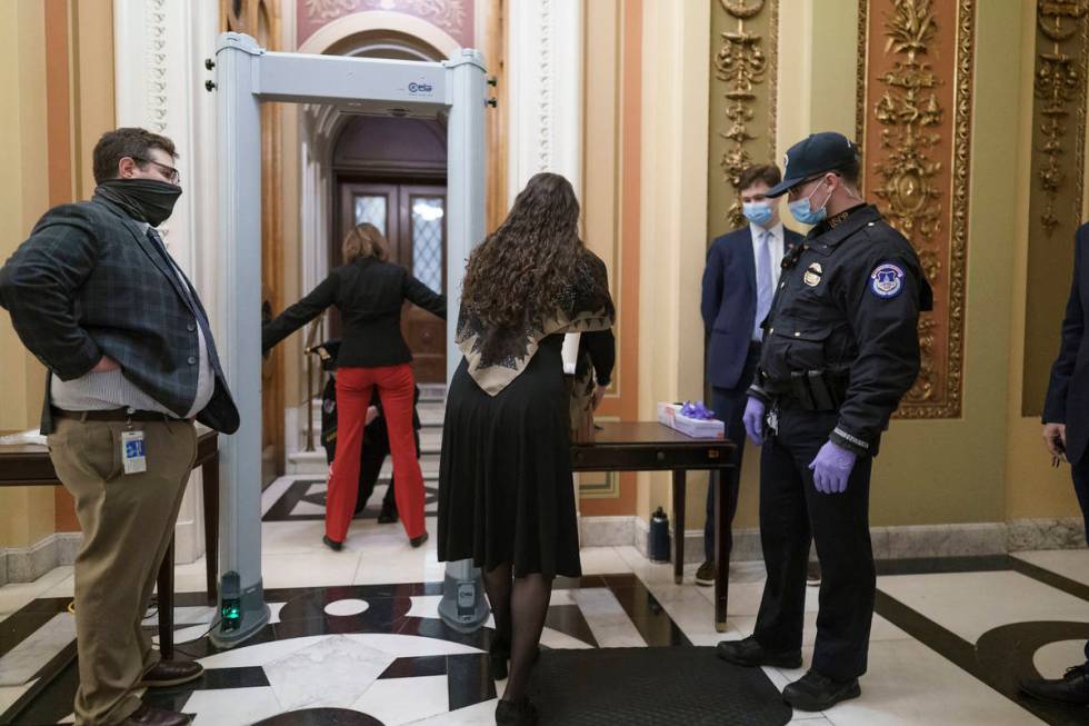 Congressional staff passes through a metal detector and security screening as they enter the Ho ...