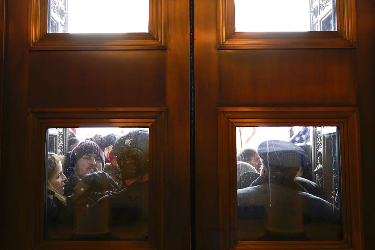 U.S. Capitol Police try to hold back rioters outside the east doors to the House side of the U. ...