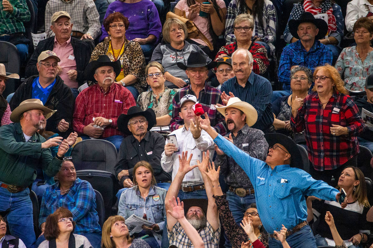 Fans reach for a free t-shirt tossed in to the crowd during the last day of the PBR World Final ...
