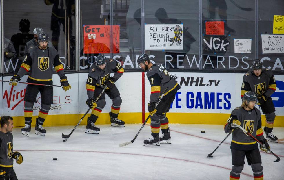 Golden Knights players warm up about handwritten signs from fans during the warm ups of an NHL ...