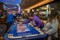 Marvin Alvarez, center, lays down more chips on a Roulette table next to girlfriend Celia Gamer ...