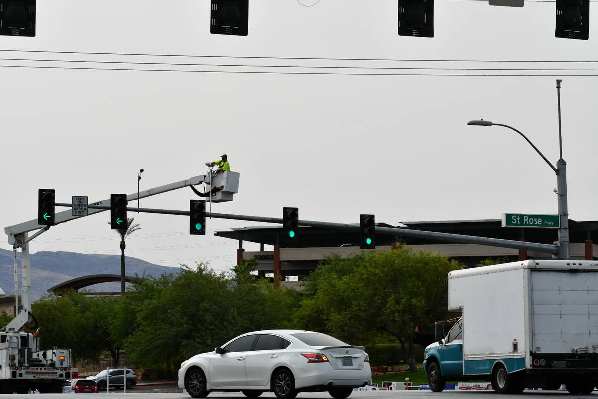 A city of Henderson worker installs adaptive traffic signal equipment as part of the a pilot pr ...