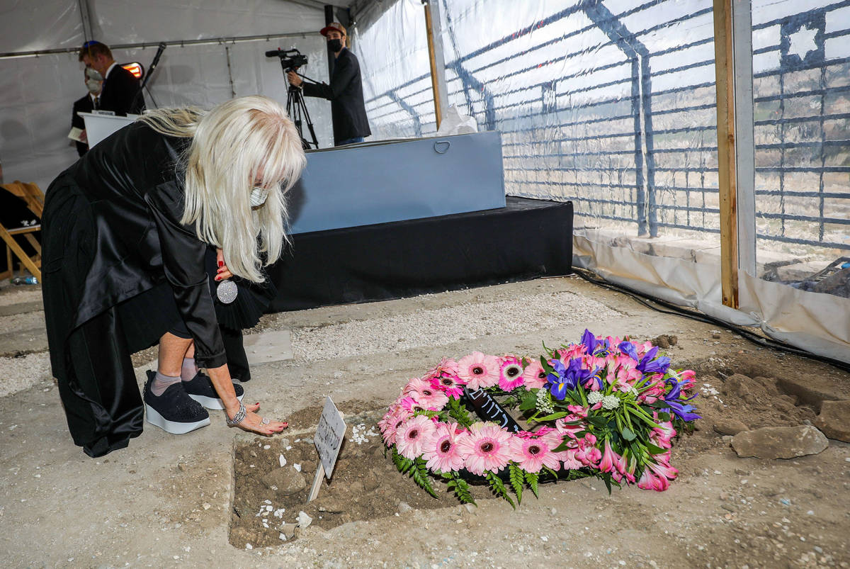 Dr. Miriam Adelson mourns next to the grave of her late husband, Sheldon Adelson, at his funera ...